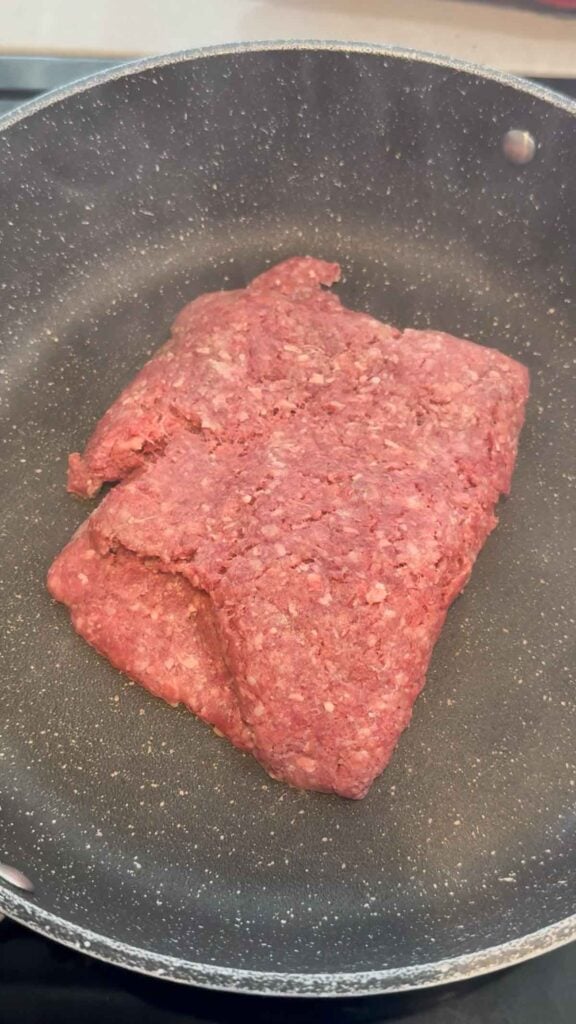 raw ground beef in a skillet