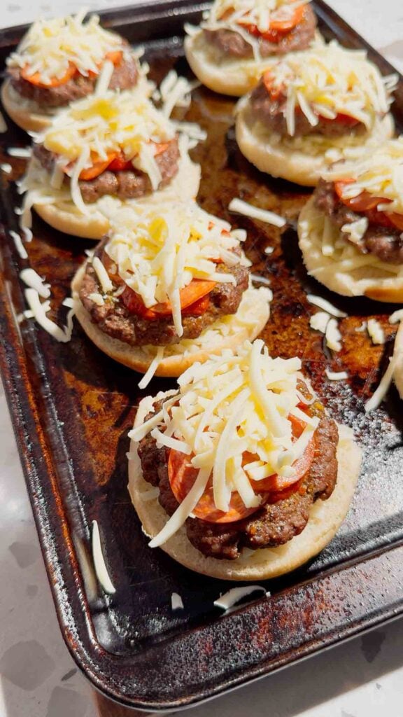 shredded mozzarella and pepperoni on top of burger patties