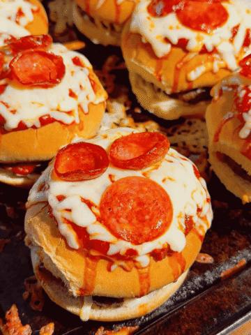 Looking for the ultimate Pizza Burgers recipe? These easy Pizza Burger sandwiches combine juicy seasoned ground beef, gooey mozzarella cheese, pizza sauce, pepperoni, and soft hamburger buns for the perfect family-friendly dinner. If you love Pizza Burger Recipes, Easy Ground Beef Recipes, Weeknight Dinner Ideas, Pizza Sloppy Joes, Cheeseburger Recipes, Pizza Sandwiches, Easy Dinner Recipes For Family, Quick Dinner Ideas, Ground Beef Dinner Recipes, Comfort Food Recipes, Baked Burgers, and fun Pizza Night Ideas, this recipe belongs on your menu. Ready in just 35 minutes with simple ingredients, these cheesy oven-baked burgers are perfect for busy weeknights, game day, parties, or whenever you're craving the flavors of pizza and burgers in one irresistible meal.