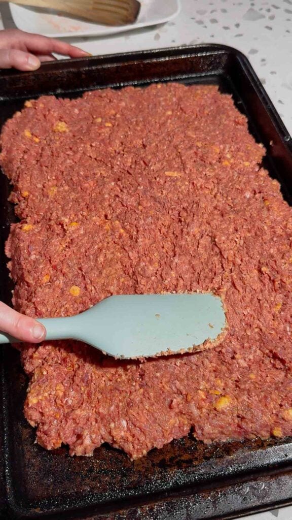 spreading meatloaf mixture on a baking sheet