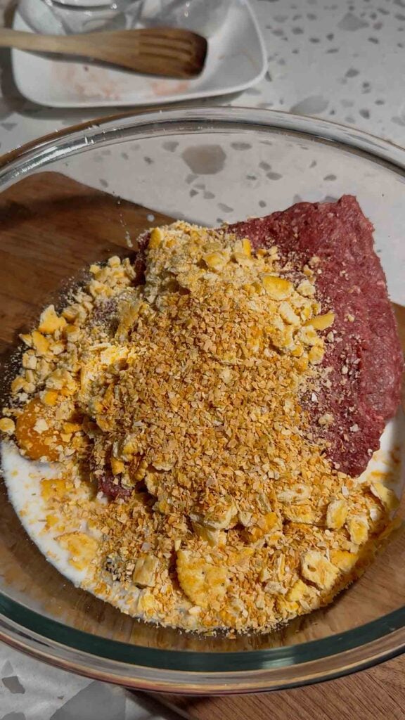 dehydrated minced onion, crushed Ritz crackers, milk, eggs and ground beef in a glass bowl
