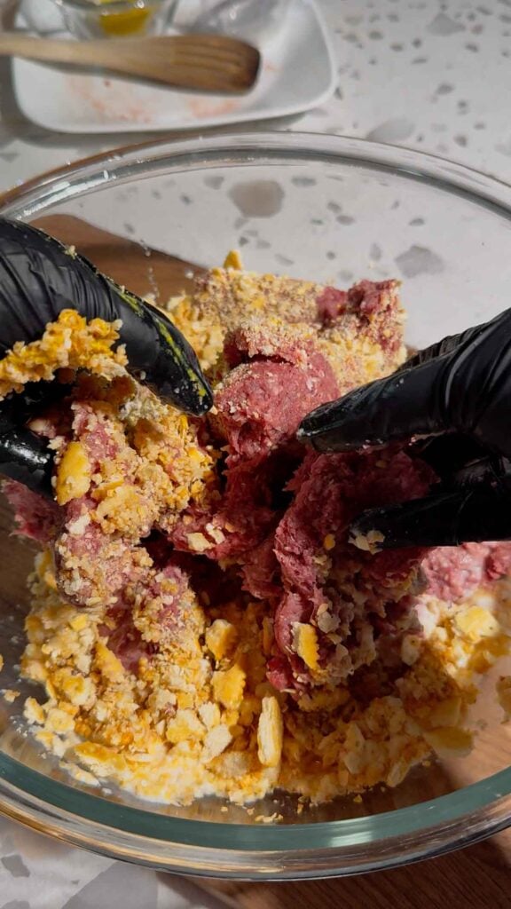 combining meatloaf ingredients in a glass bowl