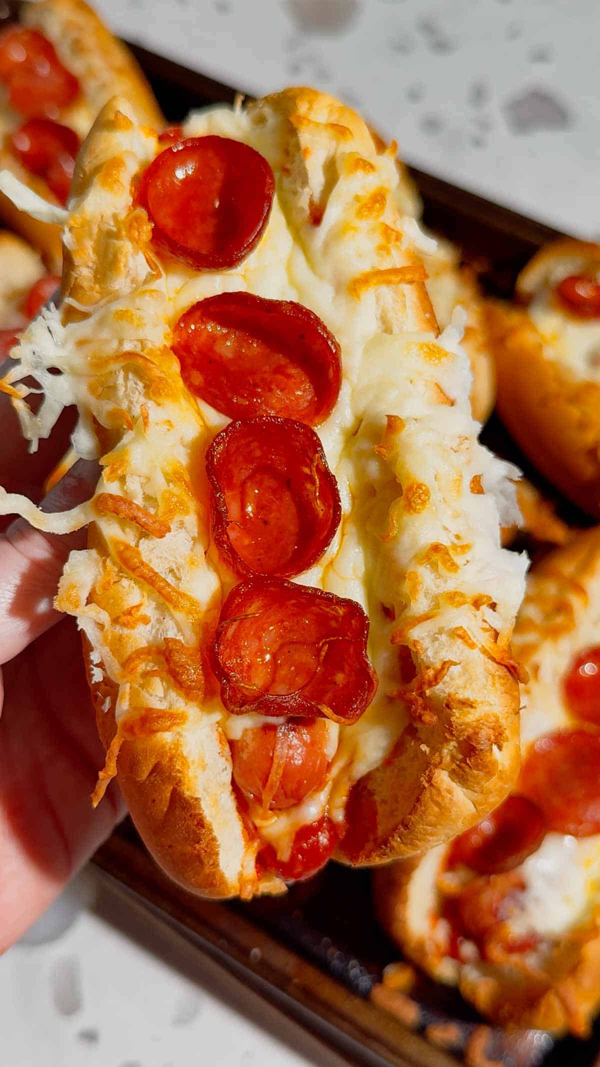 These Sheet Pan Pizza Dogs are the ultimate easy family dinner for busy nights! If you're looking for Weeknight Dinner Ideas, Easy Dinner Recipes For Family, or Quick Dinner Ideas everyone will actually eat, this fun mashup of pizza and hot dogs is a guaranteed winner. Crispy hot dog buns are loaded with pizza sauce, pepperoni, melty mozzarella cheese, and juicy hot dogs for a cheesy meal that's ready in under 20 minutes. Perfect for Lazy Dinners, Kid Friendly Meals, Game Day Food, Easy Supper Recipes, Family Dinner Ideas, Quick And Easy Dinner Recipes, Budget Friendly Meals, Easy Sheet Pan Recipes, Pizza Recipes, Hot Dog Recipes, and Simple Weeknight Meals. Save this easy pizza dog recipe for your next fast dinner, party, or fun family meal!