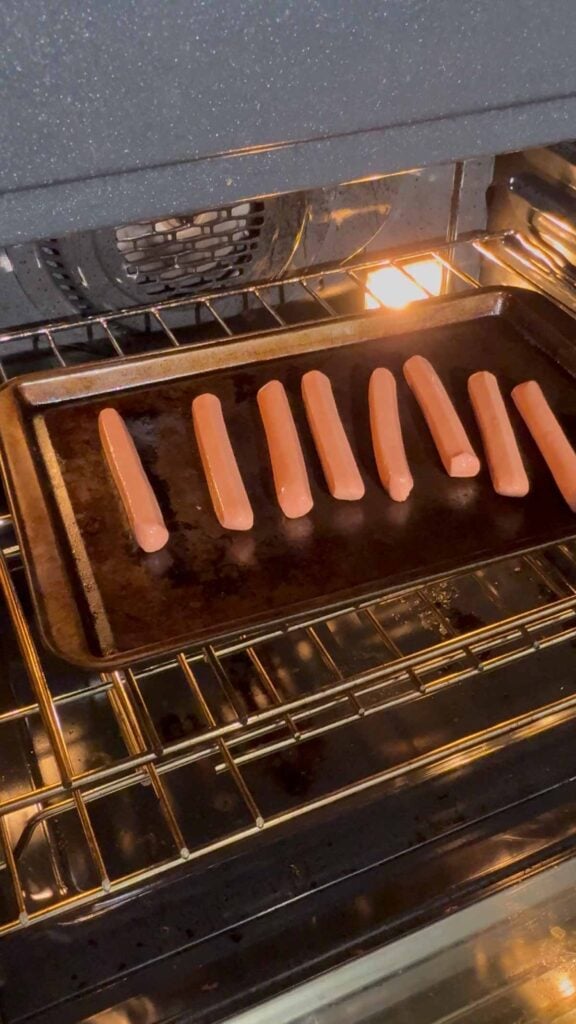 wieners on a baking sheet in the oven