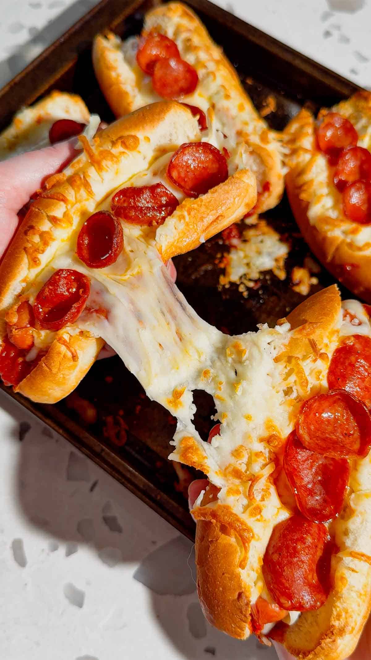 These Sheet Pan Pizza Dogs are the ultimate easy family dinner for busy nights! If you're looking for Weeknight Dinner Ideas, Easy Dinner Recipes For Family, or Quick Dinner Ideas everyone will actually eat, this fun mashup of pizza and hot dogs is a guaranteed winner. Crispy hot dog buns are loaded with pizza sauce, pepperoni, melty mozzarella cheese, and juicy hot dogs for a cheesy meal that's ready in under 20 minutes. Perfect for Lazy Dinners, Kid Friendly Meals, Game Day Food, Easy Supper Recipes, Family Dinner Ideas, Quick And Easy Dinner Recipes, Budget Friendly Meals, Easy Sheet Pan Recipes, Pizza Recipes, Hot Dog Recipes, and Simple Weeknight Meals. Save this easy pizza dog recipe for your next fast dinner, party, or fun family meal!