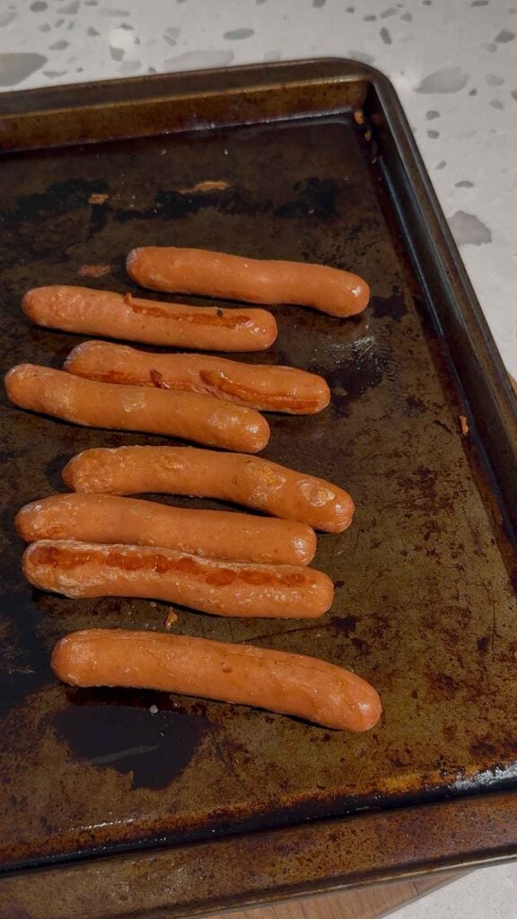 cooked wieners on a baking sheet