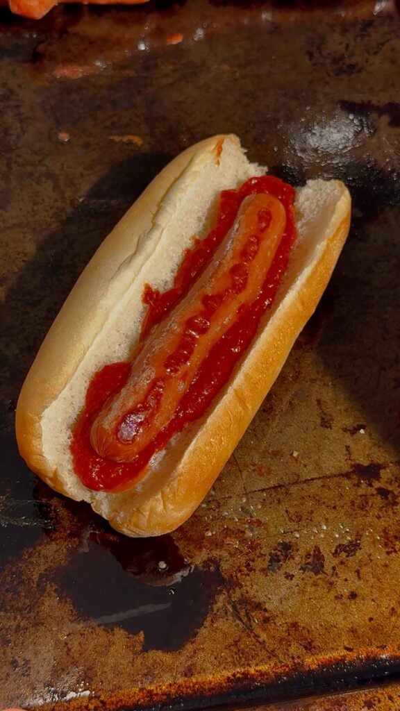 wiener and pizza sauce on a hot dog bun
