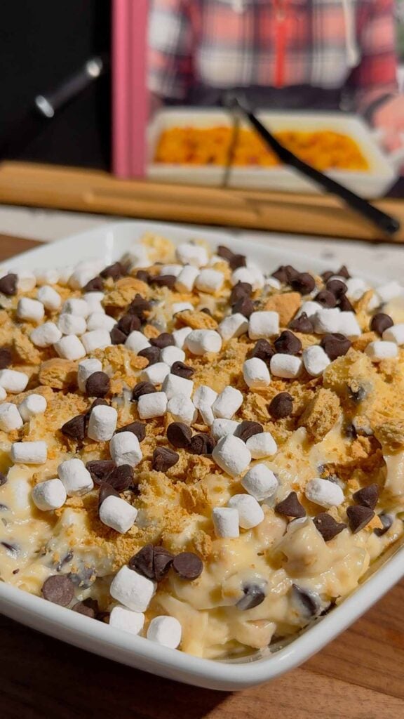 Looking for the ultimate S'mores Cookie Dough Dip to impress a crowd? This easy no bake dessert dip is rich, creamy, and loaded with mini chocolate chips, graham cracker crumbs, and marshmallows for that classic campfire flavor everyone loves. Perfect for Dessert Dips, No Bake Desserts, Easy Party Desserts, Cookie Dough Dip, S'mores Dessert Recipes, Summer Dessert Ideas, Sweet Dip Recipes, Holiday Dessert Ideas, Potluck Desserts, Game Day Desserts, Easy Dessert Recipes, and Fun Family Treats. Serve it with graham crackers, vanilla wafers, pretzels, strawberries, or apple slices for an irresistible dessert platter that's ready in only 10 minutes. Save this quick and easy dessert recipe for your next party, BBQ, movie night, or family gathering!
