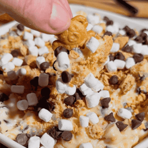 Looking for the ultimate S'mores Cookie Dough Dip to impress a crowd? This easy no bake dessert dip is rich, creamy, and loaded with mini chocolate chips, graham cracker crumbs, and marshmallows for that classic campfire flavor everyone loves. Perfect for Dessert Dips, No Bake Desserts, Easy Party Desserts, Cookie Dough Dip, S'mores Dessert Recipes, Summer Dessert Ideas, Sweet Dip Recipes, Holiday Dessert Ideas, Potluck Desserts, Game Day Desserts, Easy Dessert Recipes, and Fun Family Treats. Serve it with graham crackers, vanilla wafers, pretzels, strawberries, or apple slices for an irresistible dessert platter that's ready in only 10 minutes. Save this quick and easy dessert recipe for your next party, BBQ, movie night, or family gathering!