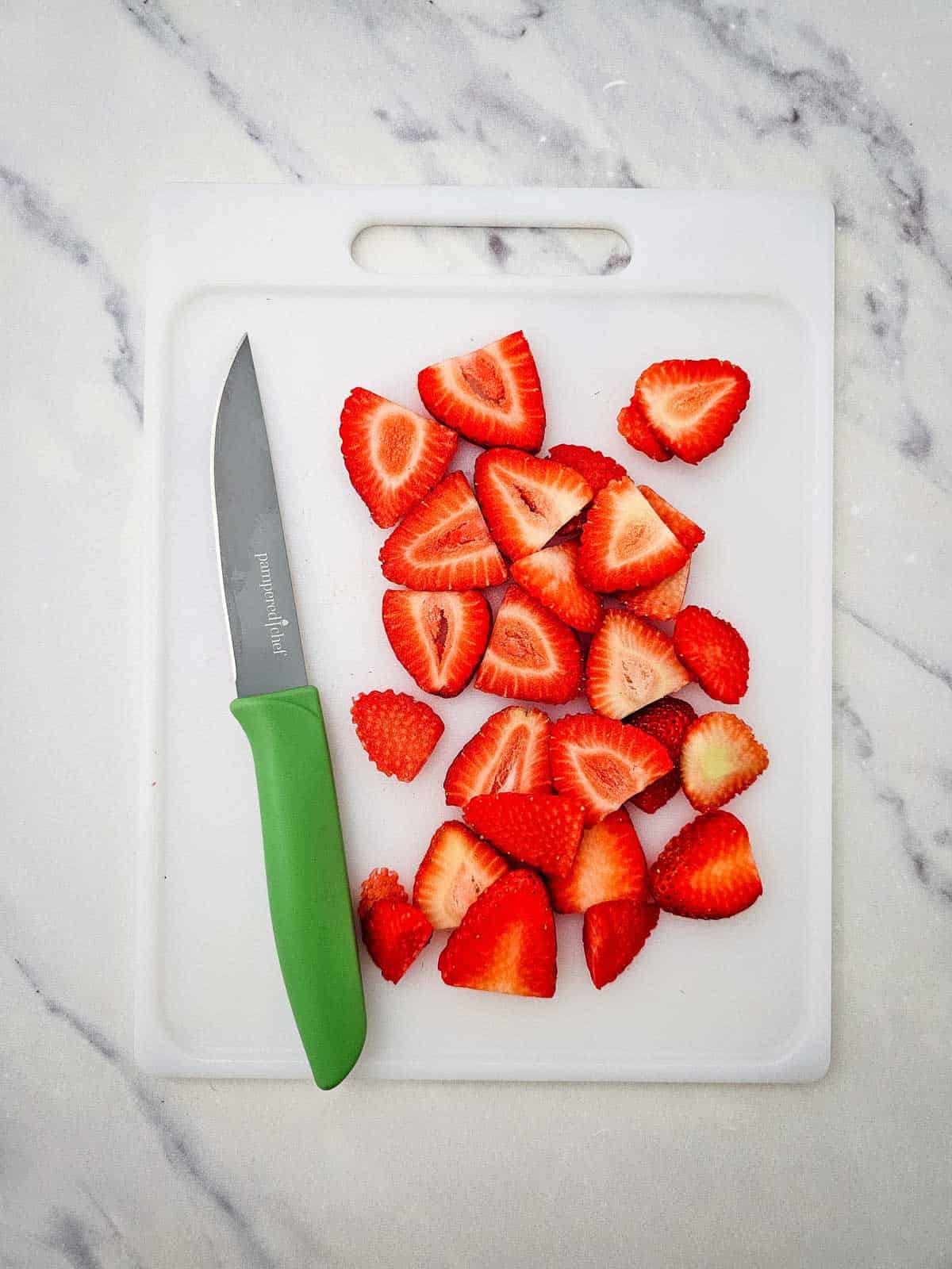 sliced strawberries on a cutting board