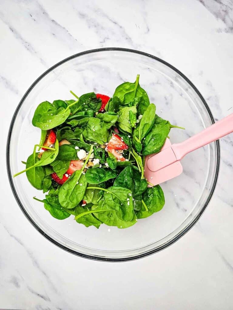 strawberry spinach salad after tossing ingredients together