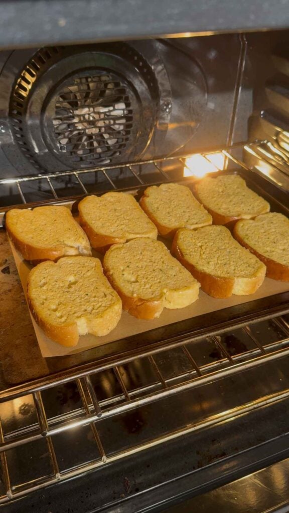 frozen texas toast garlic bread slices on a baking sheet in the oven