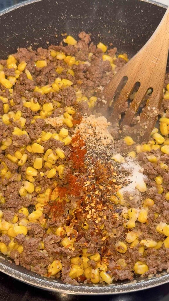 spices added so a skillet with cooked ground beef and corn