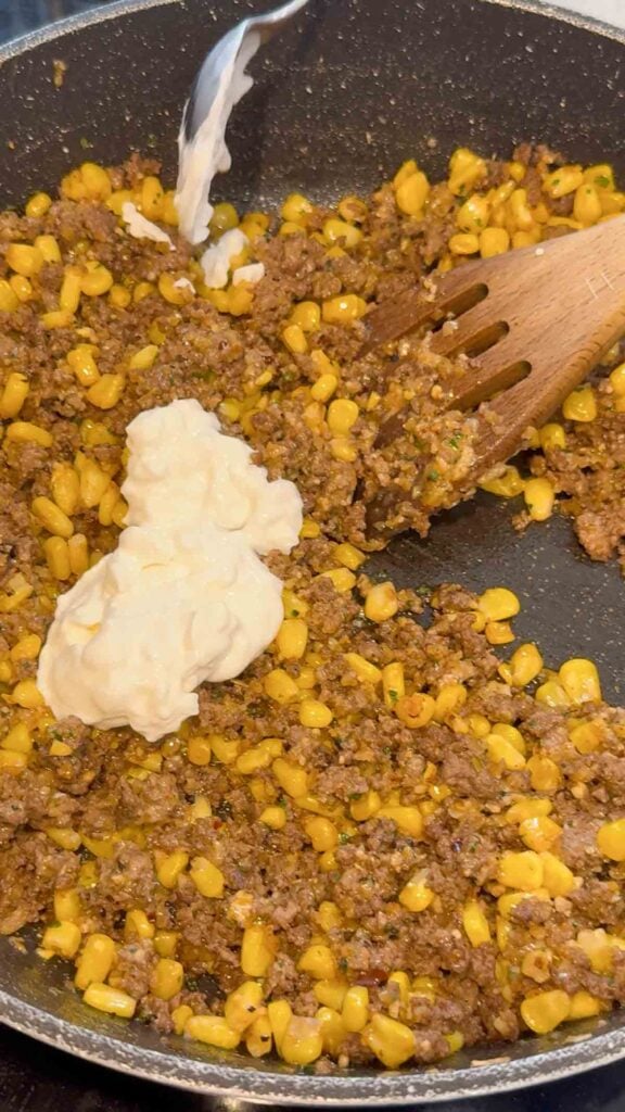 sour cream added to skillet with cooked ground beef and corn