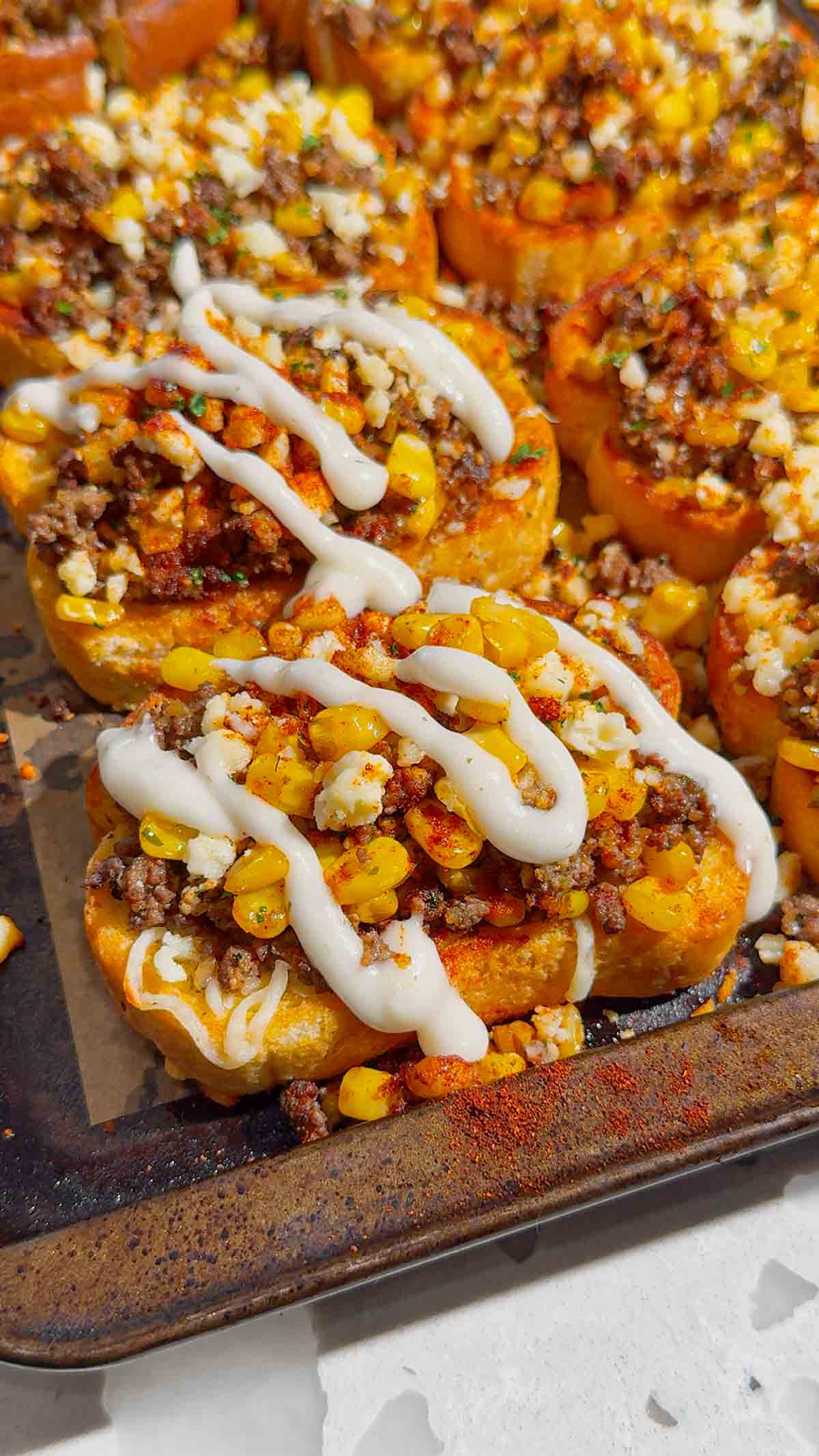 Need an easy dinner that's guaranteed to disappear fast? These Street Corn Beef Garlic Toasts combine crispy Texas garlic toast with seasoned ground beef, smoky street corn, melty mozzarella, tangy Cotija cheese, and a creamy lime sauce for the ultimate family meal. This easy ground beef recipe is perfect for busy weeknights, game day appetizers, party snacks, or quick comfort food dinners. If you're searching for easy dinner recipes, garlic bread recipes, ground beef dinner ideas, Texas toast recipes, Mexican-inspired recipes, street corn recipes, cheesy beef recipes, easy appetizer ideas, or family-friendly meals, this delicious recipe is packed with bold flavor, simple ingredients, and is ready in just 35 minutes. Save this recipe for your next easy weeknight dinner!