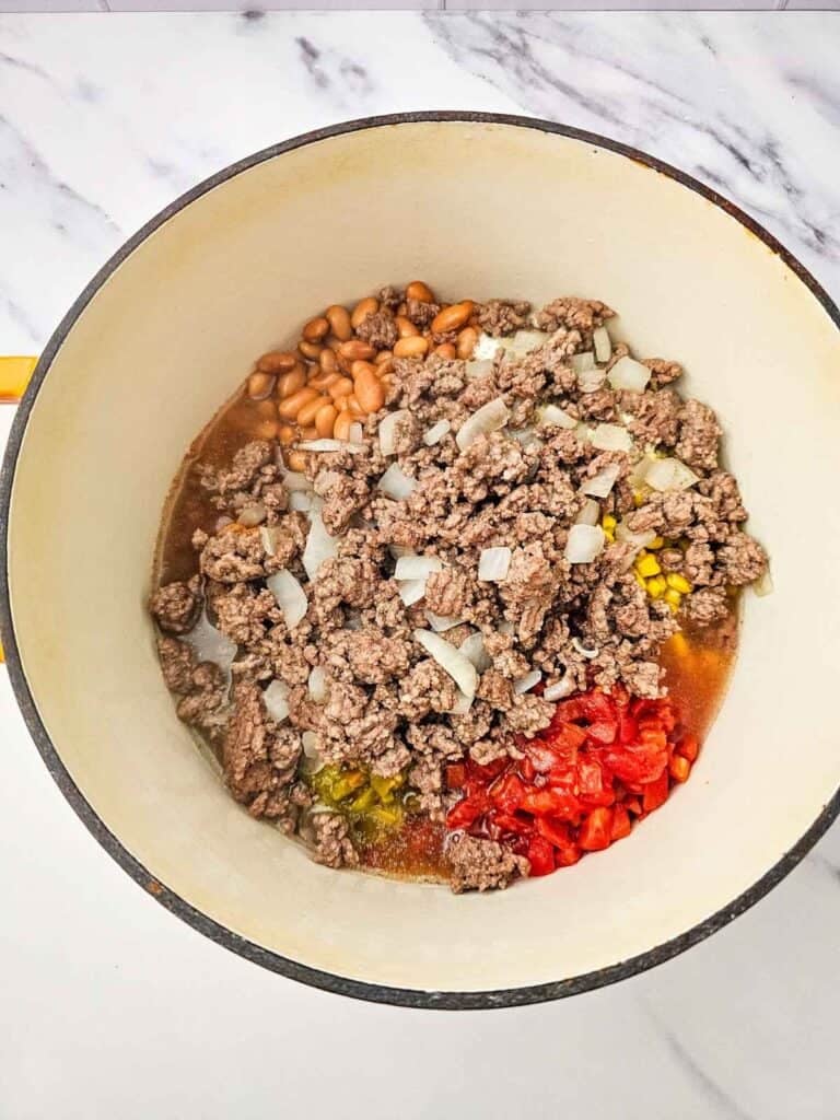 enchilada sauce, cooked ground beef, diced onions, tomatoes and beans in a large pot