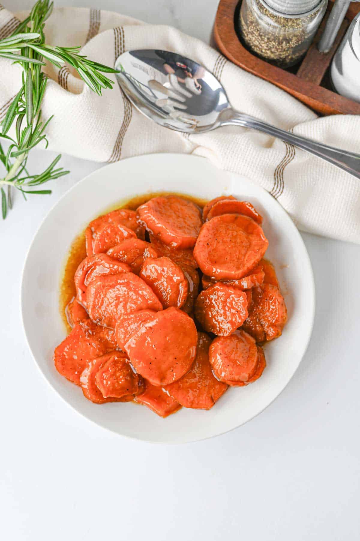 These Candied Sweet Potatoes are the ultimate sweet and buttery side dish for Thanksgiving, Christmas, Sunday dinner, and cozy fall meals! Tender sliced sweet potatoes are baked in a rich brown sugar and maple syrup glaze with butter, cinnamon, nutmeg, ginger, and vanilla for incredible caramelized flavor in every bite. If you’re searching for an Easy Candied Sweet Potatoes Recipe, Southern Candied Sweet Potatoes, Baked Sweet Potato Recipes, Thanksgiving Sweet Potato Recipes, Holiday Side Dishes, or Easy Thanksgiving Sides, save this one! These Maple Candied Sweet Potatoes require simple ingredients and just 20 minutes of prep. Serve these glazed sweet potatoes alongside turkey, ham, chicken, or roast beef for a comforting side dish everyone will be excited to see on the dinner table.