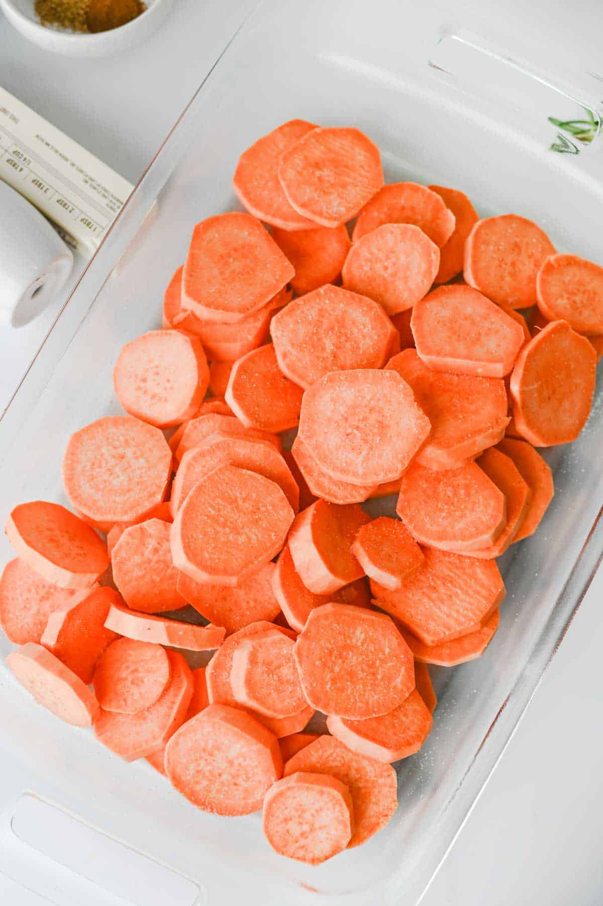 sliced sweet potatoes in a glass baking dish