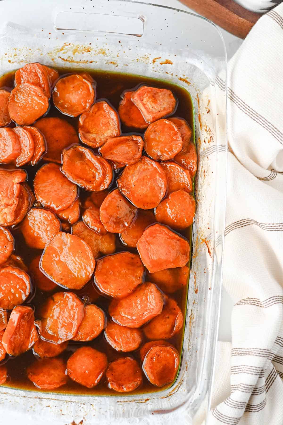 These Candied Sweet Potatoes are the ultimate sweet and buttery side dish for Thanksgiving, Christmas, Sunday dinner, and cozy fall meals! Tender sliced sweet potatoes are baked in a rich brown sugar and maple syrup glaze with butter, cinnamon, nutmeg, ginger, and vanilla for incredible caramelized flavor in every bite. If you’re searching for an Easy Candied Sweet Potatoes Recipe, Southern Candied Sweet Potatoes, Baked Sweet Potato Recipes, Thanksgiving Sweet Potato Recipes, Holiday Side Dishes, or Easy Thanksgiving Sides, save this one! These Maple Candied Sweet Potatoes require simple ingredients and just 20 minutes of prep. Serve these glazed sweet potatoes alongside turkey, ham, chicken, or roast beef for a comforting side dish everyone will be excited to see on the dinner table.