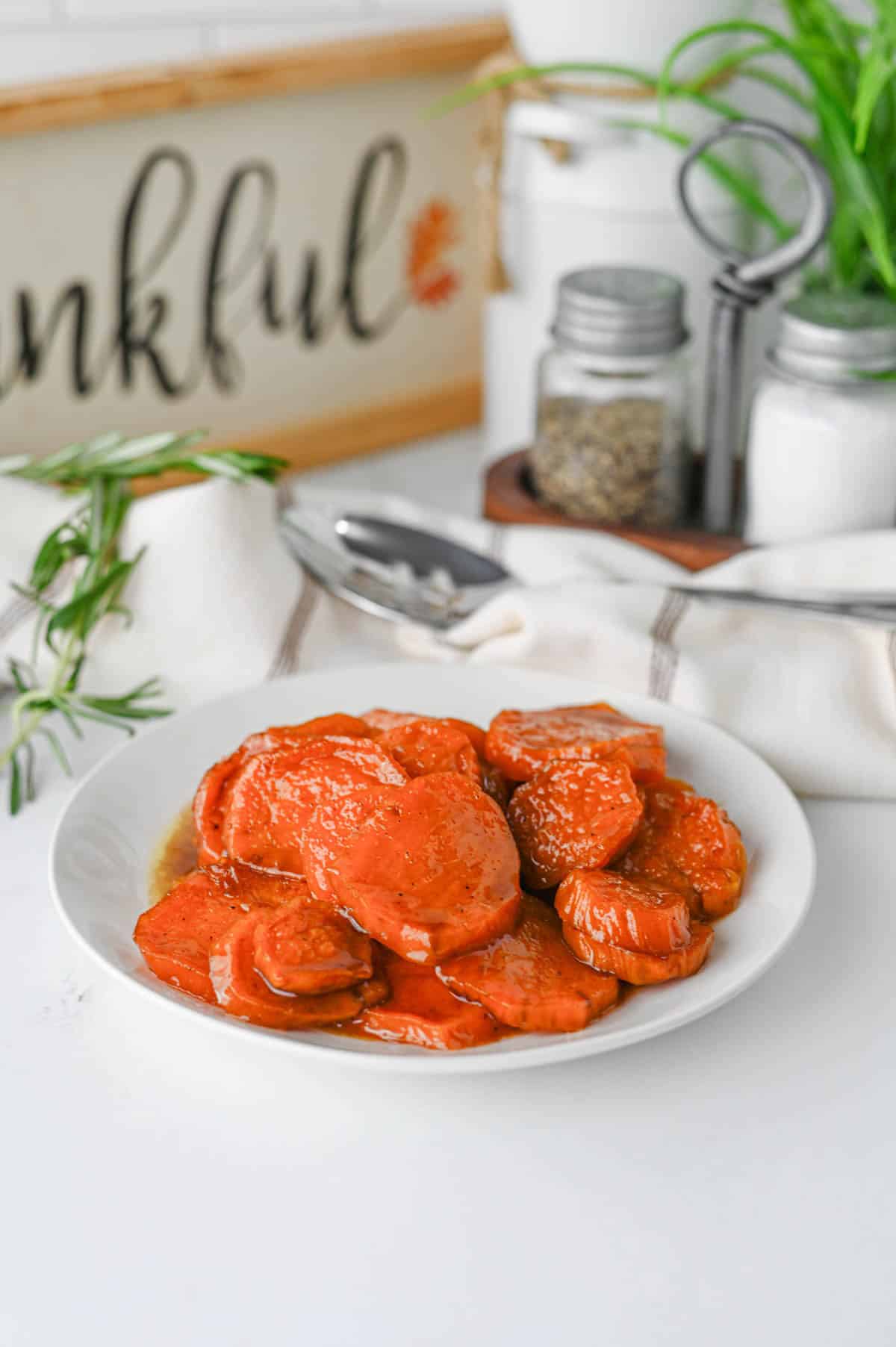 These Candied Sweet Potatoes are the ultimate sweet and buttery side dish for Thanksgiving, Christmas, Sunday dinner, and cozy fall meals! Tender sliced sweet potatoes are baked in a rich brown sugar and maple syrup glaze with butter, cinnamon, nutmeg, ginger, and vanilla for incredible caramelized flavor in every bite. If you’re searching for an Easy Candied Sweet Potatoes Recipe, Southern Candied Sweet Potatoes, Baked Sweet Potato Recipes, Thanksgiving Sweet Potato Recipes, Holiday Side Dishes, or Easy Thanksgiving Sides, save this one! These Maple Candied Sweet Potatoes require simple ingredients and just 20 minutes of prep. Serve these glazed sweet potatoes alongside turkey, ham, chicken, or roast beef for a comforting side dish everyone will be excited to see on the dinner table.