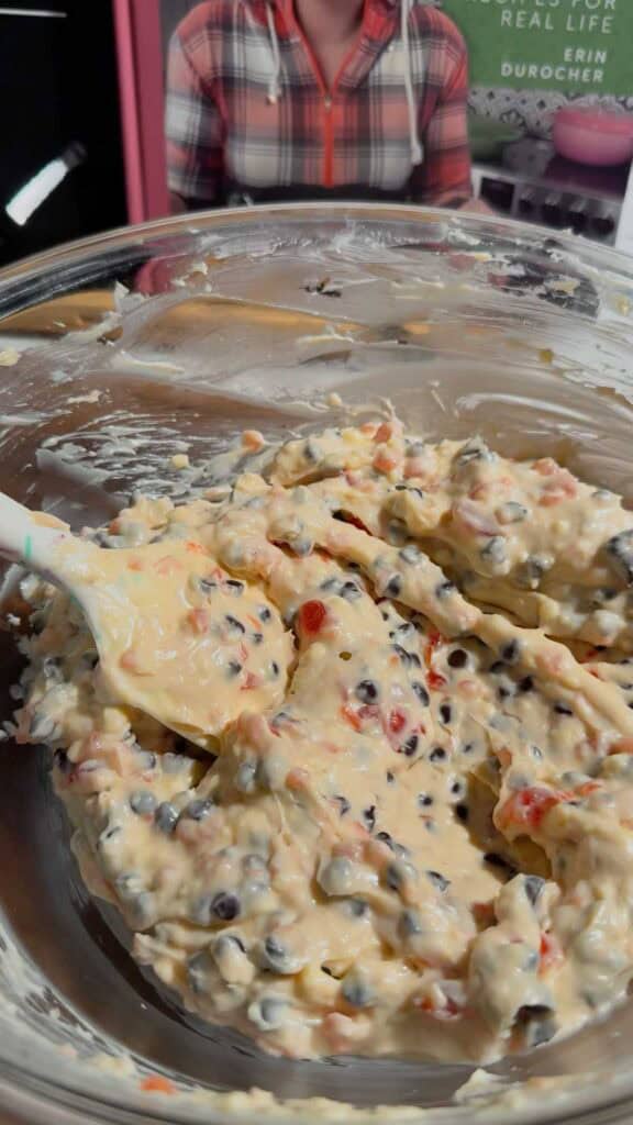 stirring cherry chocolate chip dip in a glass mixing bowl