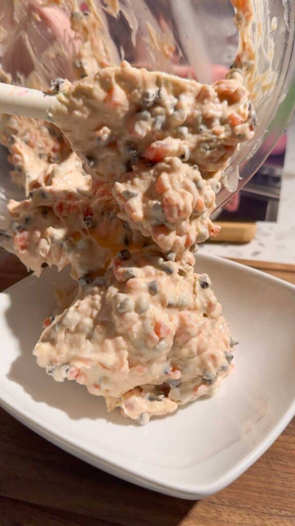 scooping cherry chocolate chip dip into a serving bowl