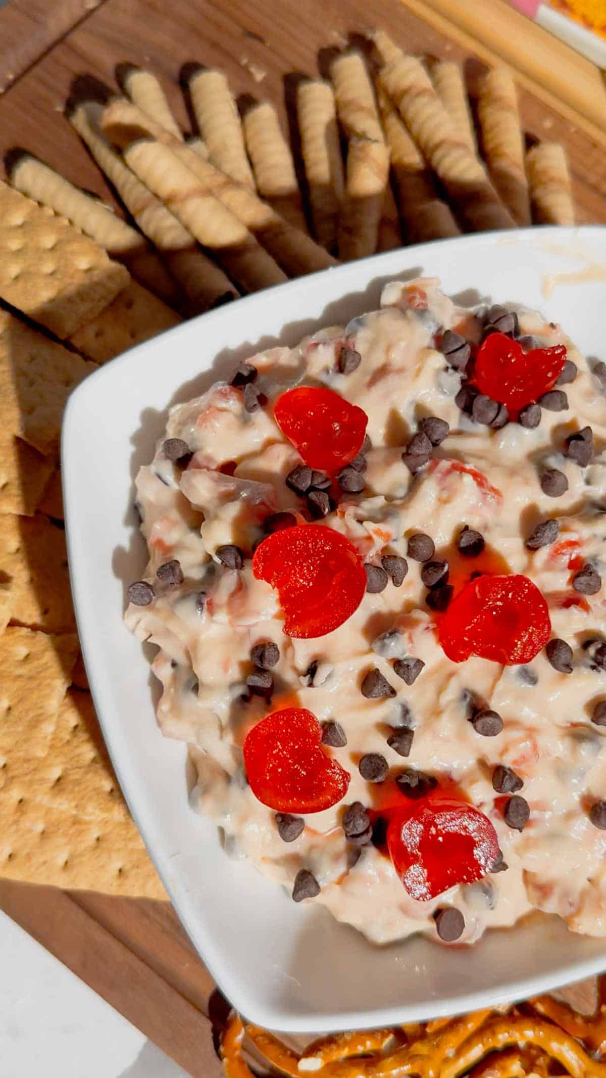 Cherry Chocolate Chip Dip is an easy no bake dessert dip loaded with creamy cream cheese, sweet cherries and mini chocolate chips. This quick dessert dip takes just 15 minutes to make and is perfect for parties, holidays, potlucks, Valentine's Day treats and easy entertaining. If you love chocolate chip dip, cherry desserts, cheesecake dip and sweet cream cheese dip recipes, this simple party dessert is a must-try. Serve this cherry chocolate chip cheesecake dip with graham crackers, vanilla wafers, pretzels, cookies or fresh fruit for dipping. Made with cream cheese, butter, brown sugar, vanilla, candied cherries and chocolate chips, it's a rich and creamy no bake treat. Save this easy dessert dip recipe for your next party, holiday dessert table, girls' night or last-minute sweet treat!