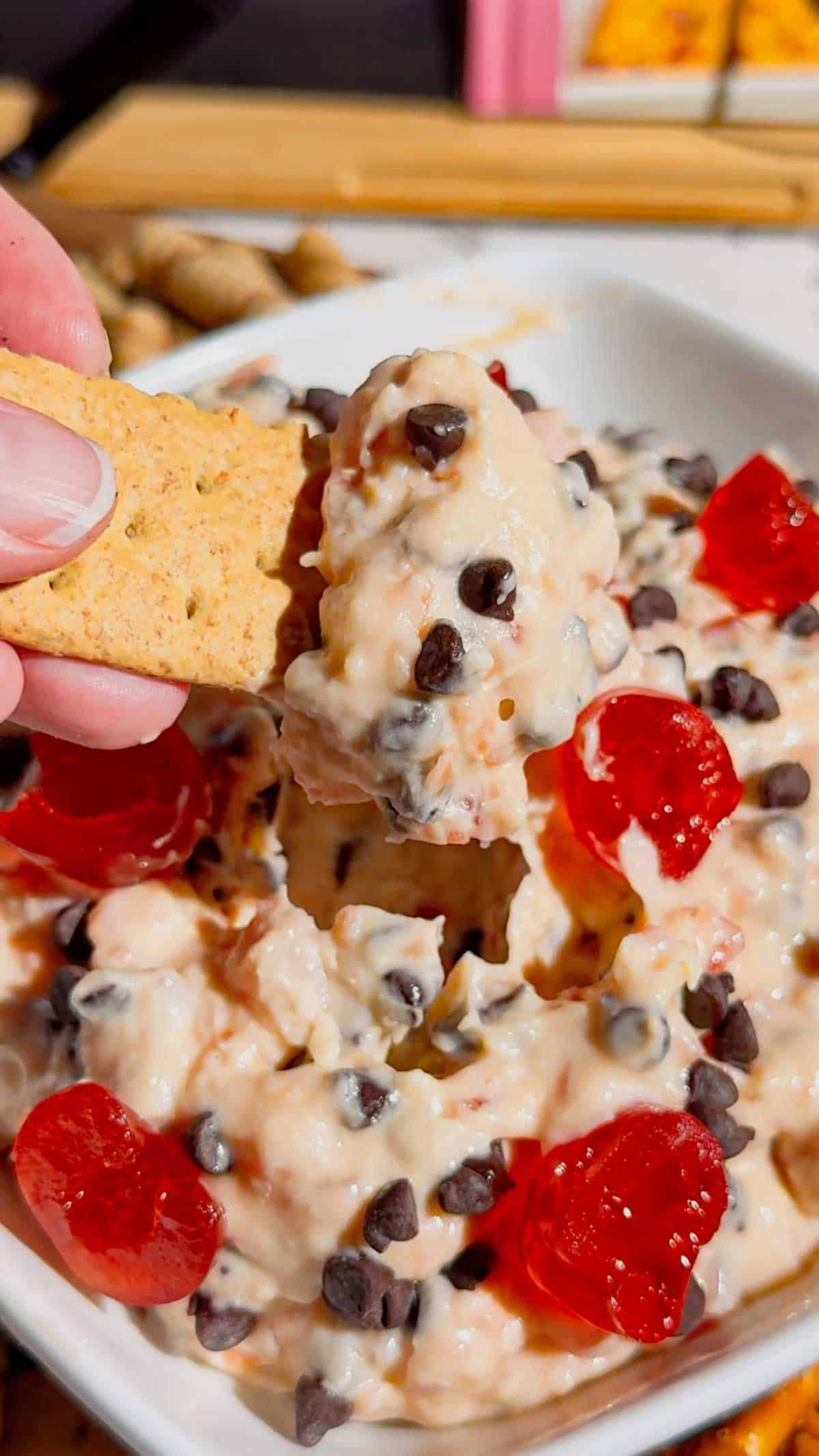 Cherry Chocolate Chip Dip is an easy no bake dessert dip loaded with creamy cream cheese, sweet cherries and mini chocolate chips. This quick dessert dip takes just 15 minutes to make and is perfect for parties, holidays, potlucks, Valentine's Day treats and easy entertaining. If you love chocolate chip dip, cherry desserts, cheesecake dip and sweet cream cheese dip recipes, this simple party dessert is a must-try. Serve this cherry chocolate chip cheesecake dip with graham crackers, vanilla wafers, pretzels, cookies or fresh fruit for dipping. Made with cream cheese, butter, brown sugar, vanilla, candied cherries and chocolate chips, it's a rich and creamy no bake treat. Save this easy dessert dip recipe for your next party, holiday dessert table, girls' night or last-minute sweet treat!