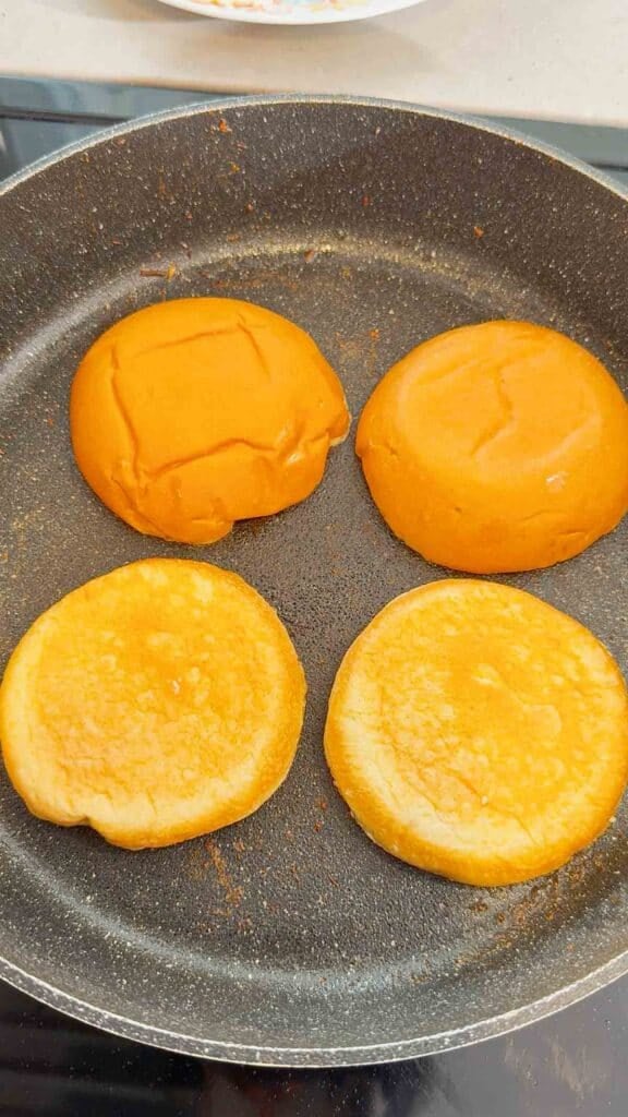 hamburger buns toasting in a skillet