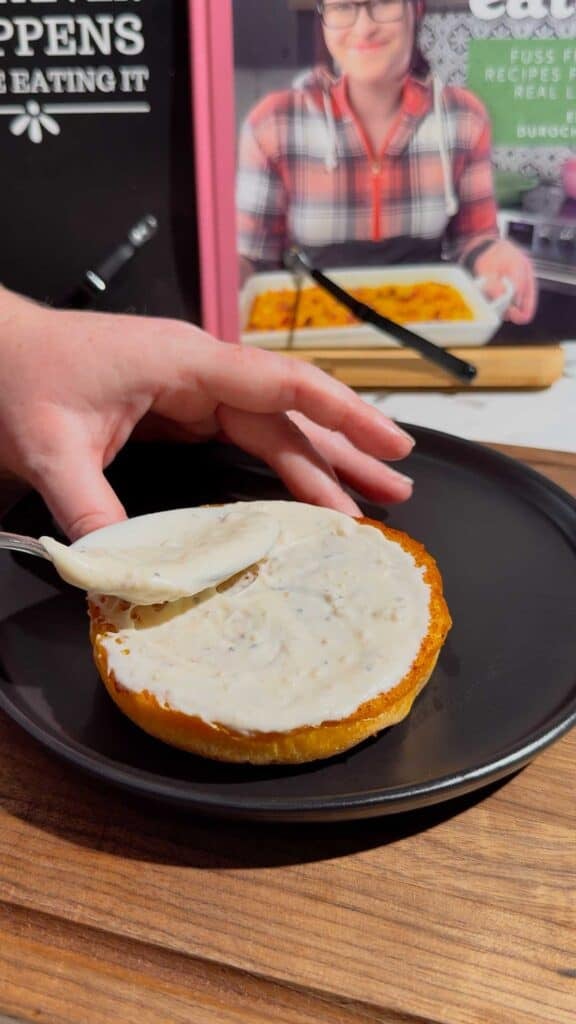 spreading ceasar dressing on a burger bun
