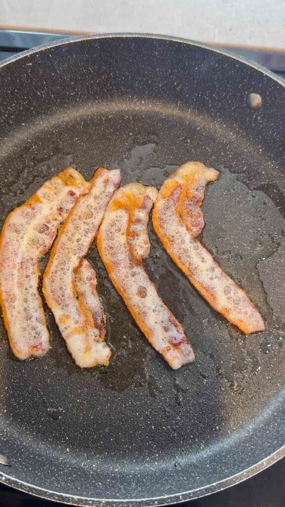 cooked bacon strips in a skillet