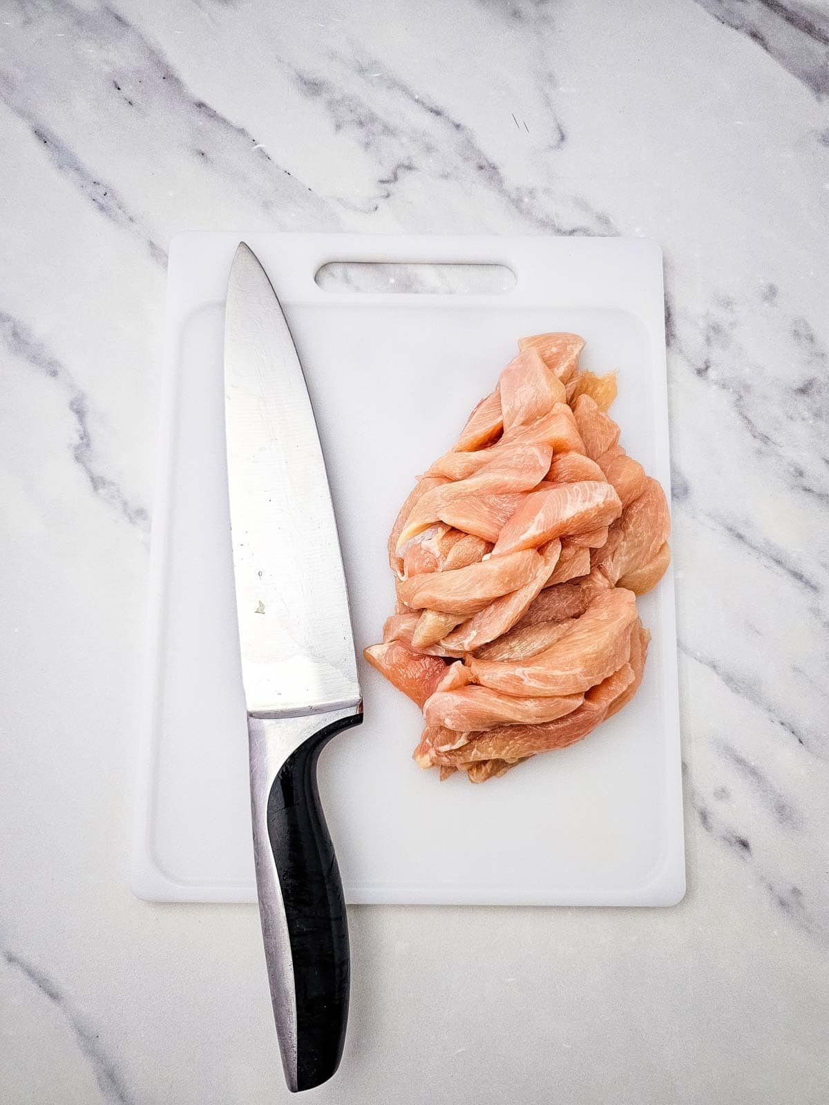sliced chicken breasts on a cutting board