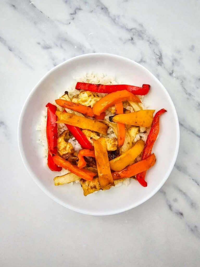 sliced peppers and chicken breasts in a bowl