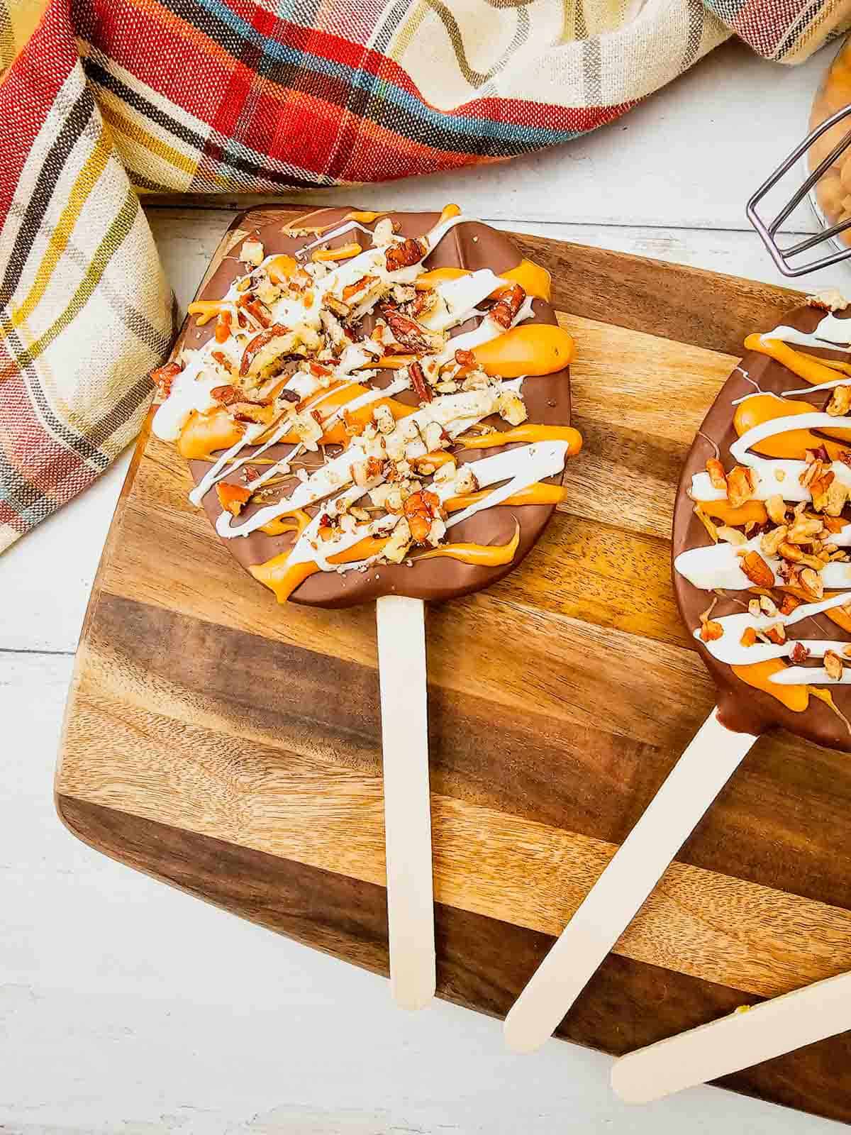 These Chocolate Caramel Apple Slice Pops are an easy fall treat combining crisp Granny Smith apples with rich chocolate, gooey caramel, white chocolate drizzle, and crunchy pecans. If you love Caramel Apple Slices, Chocolate Covered Apple Slices, or classic Caramel Apples, this simple recipe is a must-try. These Apple Slice Pops are perfect for Fall Desserts, Halloween Treats, Thanksgiving Desserts, Fall Party Food. Learn How To Make Chocolate Covered Apples with an easy twist that is less messy than whole apples. These Chocolate Caramel Apples are sweet, tart, and crunchy in every bite. Save this Easy Fall Dessert Recipe for apple season, Halloween parties, Thanksgiving, or anytime you need Easy Apple Desserts, Fall Treat Ideas, or a fun No Bake Dessert everyone will love.