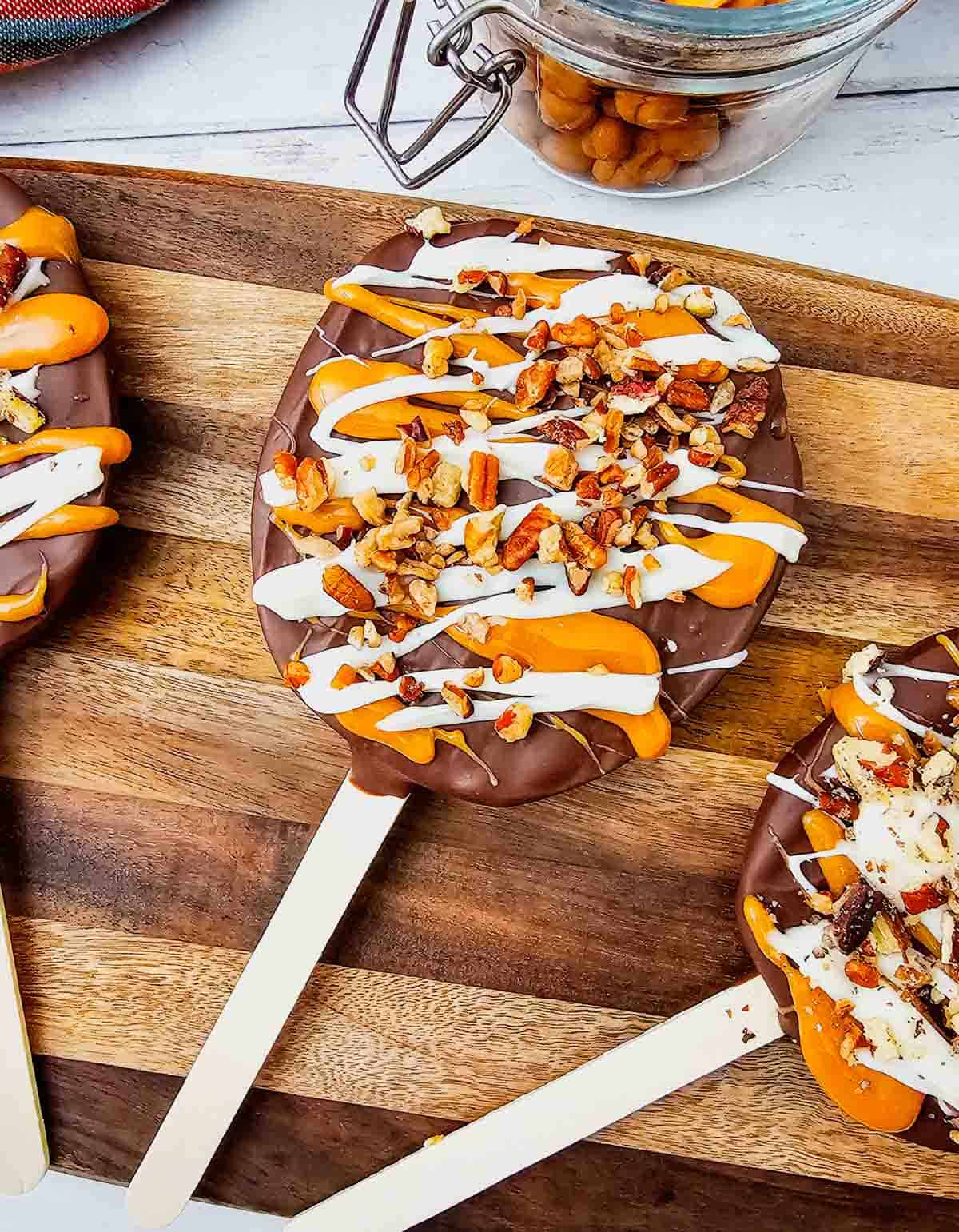 These Chocolate Caramel Apple Slice Pops are an easy fall treat combining crisp Granny Smith apples with rich chocolate, gooey caramel, white chocolate drizzle, and crunchy pecans. If you love Caramel Apple Slices, Chocolate Covered Apple Slices, or classic Caramel Apples, this simple recipe is a must-try. These Apple Slice Pops are perfect for Fall Desserts, Halloween Treats, Thanksgiving Desserts, Fall Party Food. Learn How To Make Chocolate Covered Apples with an easy twist that is less messy than whole apples. These Chocolate Caramel Apples are sweet, tart, and crunchy in every bite. Save this Easy Fall Dessert Recipe for apple season, Halloween parties, Thanksgiving, or anytime you need Easy Apple Desserts, Fall Treat Ideas, or a fun No Bake Dessert everyone will love.