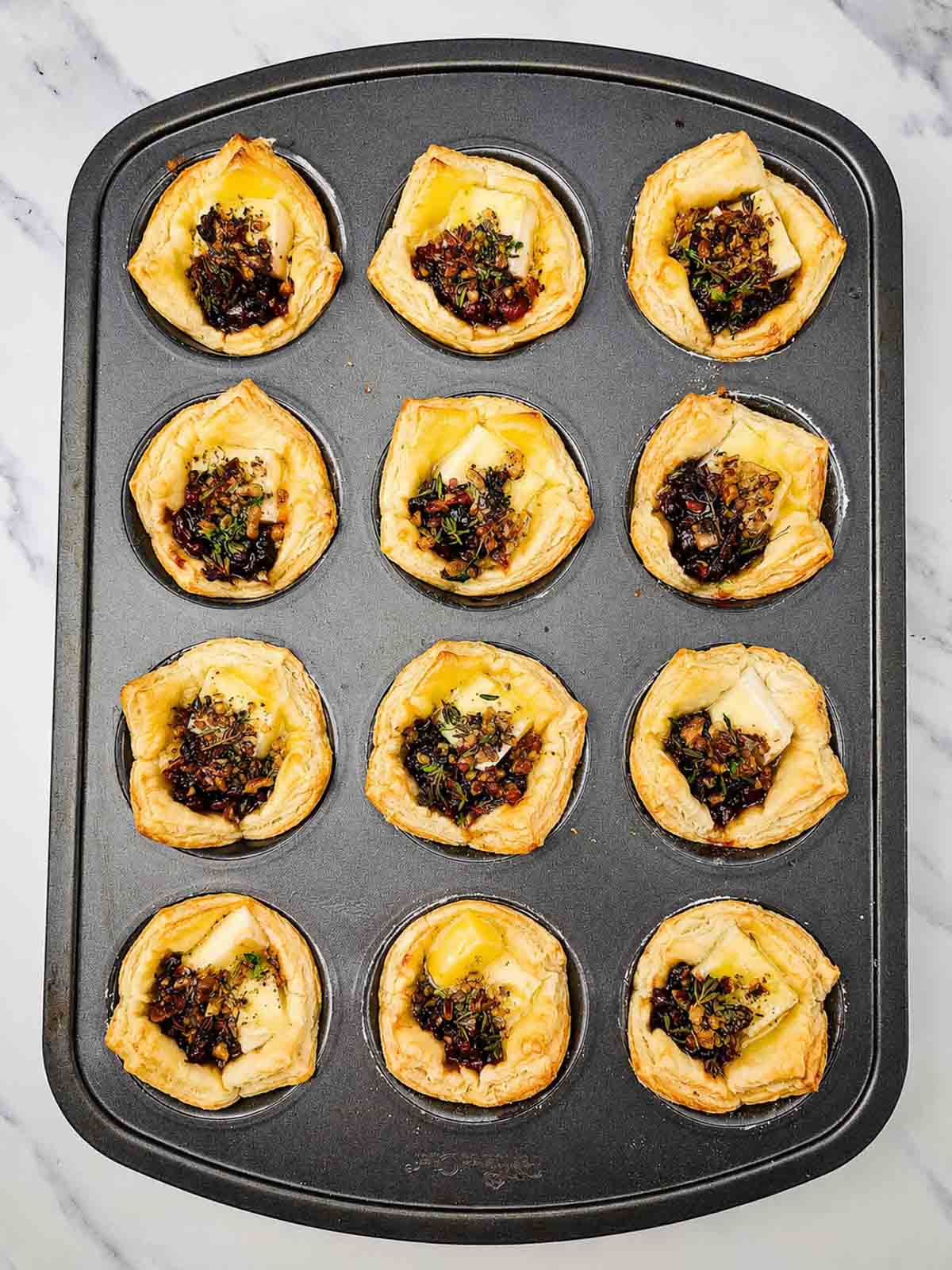 cranberry brie bites in a muffin tin after baking