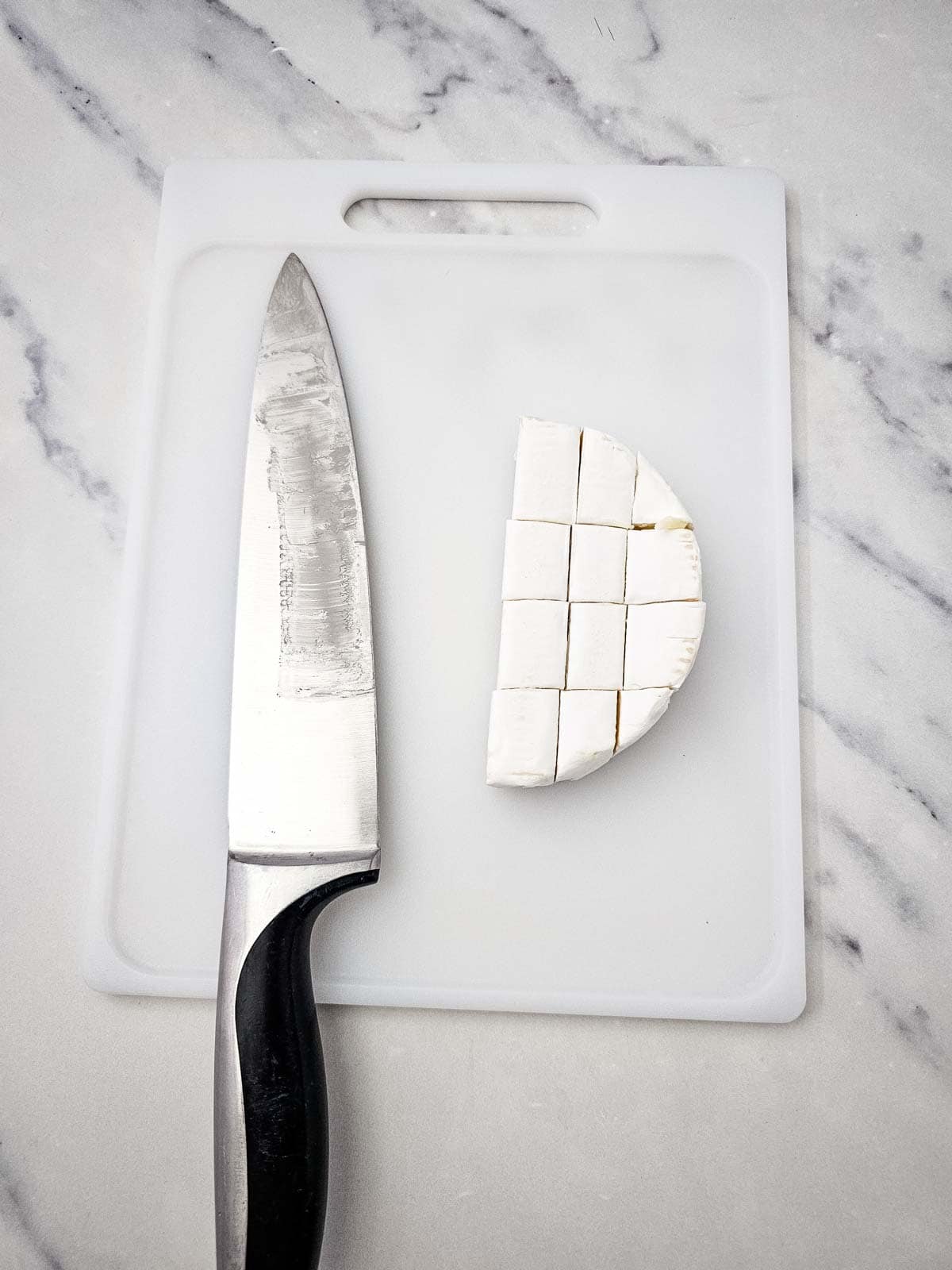 brie cut into cubes on a cutting board