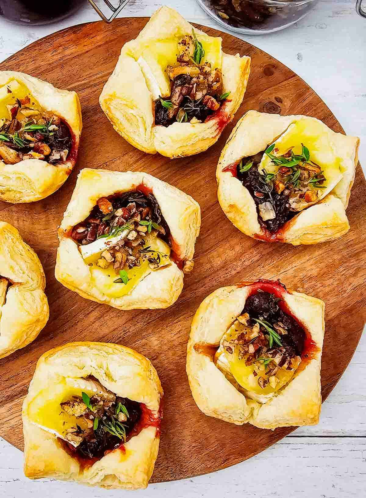 These Puff Pastry Cranberry Brie Bites are an easy holiday appetizer for entertaining. Flaky puff pastry is filled with creamy Brie cheese, sweet-tart cranberry sauce, crunchy pecans, and fresh thyme, then baked until golden and perfectly melty. This Cranberry Brie Bites recipe is perfect for Christmas appetizers, Thanksgiving appetizers, holiday party food, New Year's Eve appetizers, and easy finger foods for entertaining. If you love baked Brie, puff pastry appetizers, cranberry appetizers and Brie recipes, these bite-sized treats are a must-try. With just 5 ingredients and 15 minutes of prep, these easy holiday appetizers look elegant without the extra work. Save these Cranberry Brie Puff Pastry Bites for your next holiday gathering, potluck, Christmas dinner, or party!