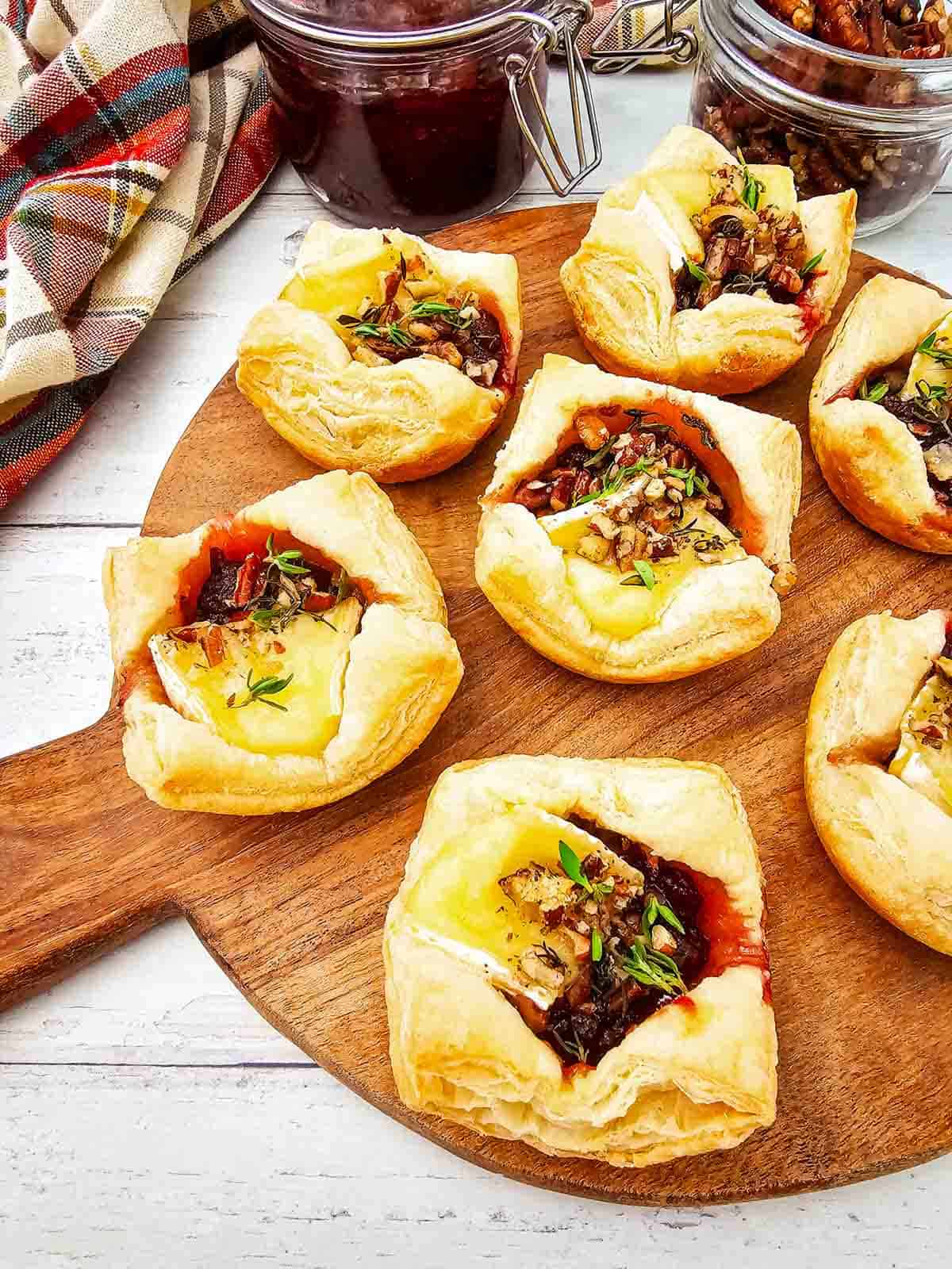 These Puff Pastry Cranberry Brie Bites are an easy holiday appetizer for entertaining. Flaky puff pastry is filled with creamy Brie cheese, sweet-tart cranberry sauce, crunchy pecans, and fresh thyme, then baked until golden and perfectly melty. This Cranberry Brie Bites recipe is perfect for Christmas appetizers, Thanksgiving appetizers, holiday party food, New Year's Eve appetizers, and easy finger foods for entertaining. If you love baked Brie, puff pastry appetizers, cranberry appetizers and Brie recipes, these bite-sized treats are a must-try. With just 5 ingredients and 15 minutes of prep, these easy holiday appetizers look elegant without the extra work. Save these Cranberry Brie Puff Pastry Bites for your next holiday gathering, potluck, Christmas dinner, or party!