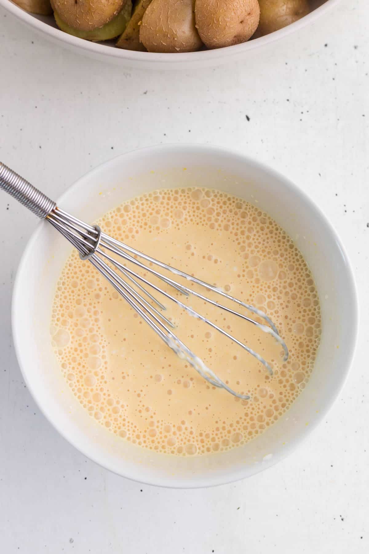 creamy dressing being whisked in a bowl