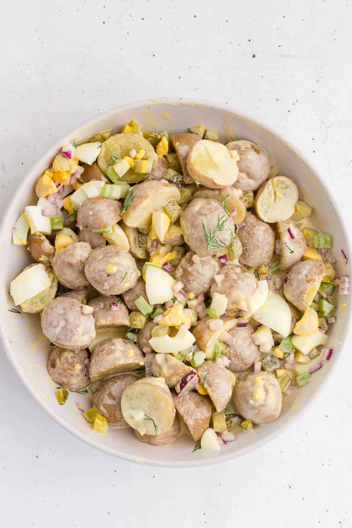 This Dill Pickle Potato Salad is the ultimate creamy and tangy summer side dish for pickle lovers! Tender baby potatoes are tossed with crunchy dill pickles, crisp celery, red onion, fresh dill, and chopped hard-boiled eggs for a flavor-packed twist on Classic Potato Salad. A creamy dressing made with mayonnaise, dill pickle juice, yellow mustard, and red wine vinegar gives this Easy Potato Salad Recipe plenty of zippy pickle flavor. Serve this Dill Pickle Potato Salad Recipe at summer BBQs, backyard cookouts, picnics, potlucks, family dinners, or holiday gatherings. If you're searching for Easy Summer Side Dishes, BBQ Side Dishes, Cold Potato Salad Recipes, Dill Pickle Recipes, Picnic Side Dishes, or the Best Potato Salad Recipe, save this creamy potato salad for later!