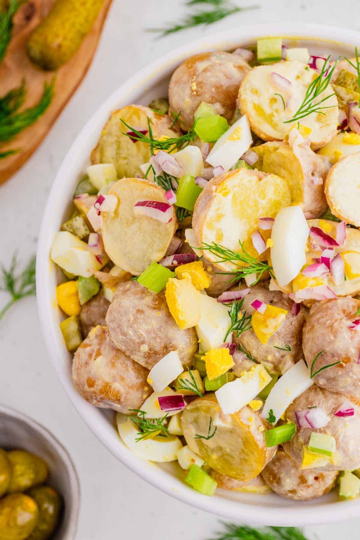 This Dill Pickle Potato Salad is the ultimate creamy and tangy summer side dish for pickle lovers! Tender baby potatoes are tossed with crunchy dill pickles, crisp celery, red onion, fresh dill, and chopped hard-boiled eggs for a flavor-packed twist on Classic Potato Salad. A creamy dressing made with mayonnaise, dill pickle juice, yellow mustard, and red wine vinegar gives this Easy Potato Salad Recipe plenty of zippy pickle flavor. Serve this Dill Pickle Potato Salad Recipe at summer BBQs, backyard cookouts, picnics, potlucks, family dinners, or holiday gatherings. If you're searching for Easy Summer Side Dishes, BBQ Side Dishes, Cold Potato Salad Recipes, Dill Pickle Recipes, Picnic Side Dishes, or the Best Potato Salad Recipe, save this creamy potato salad for later!