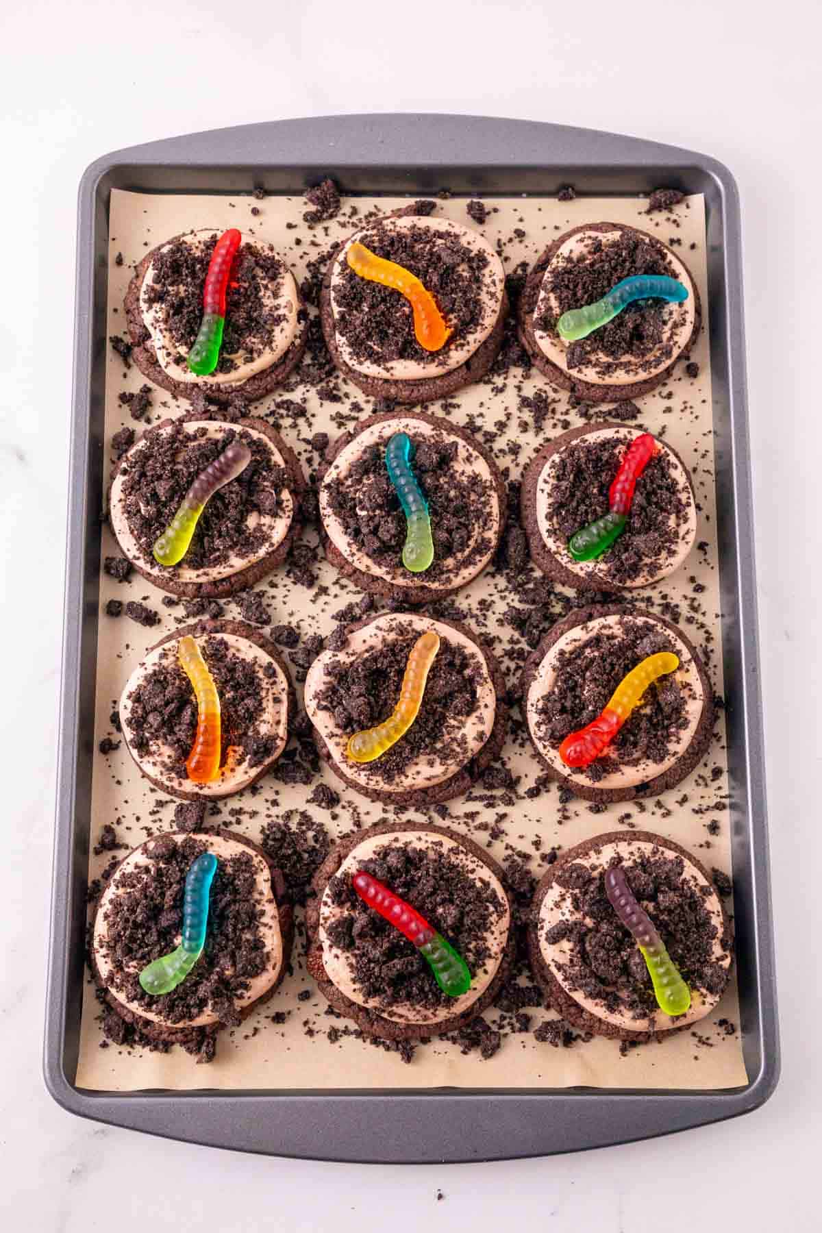 These Dirt and Worms Cookies are the ultimate fun and easy Halloween dessert for kids and adults! Rich chocolate cookies are topped with creamy Nutella frosting, crushed Oreo cookie “dirt,” and colorful gummy worms for a spooky treat that’s almost too cute to eat. If you’re searching for Halloween Cookies, Halloween Dessert Recipes, Spooky Cookies, Dirt and Worm Cookies, Gummy Worm Desserts, Oreo Desserts, or Easy Halloween Treats, save this recipe! These creepy-cute cookies are perfect for Halloween Party Food, Halloween Baking Ideas Easy, Halloween Food For Party, Halloween Treats For Kids, Spooky Halloween Desserts, Halloween Cookie Ideas, and fun classroom treats. With store bought cookie dough and simple decorating, these easy Halloween cookies come together quickly for parties, movie nights, and October celebrations.