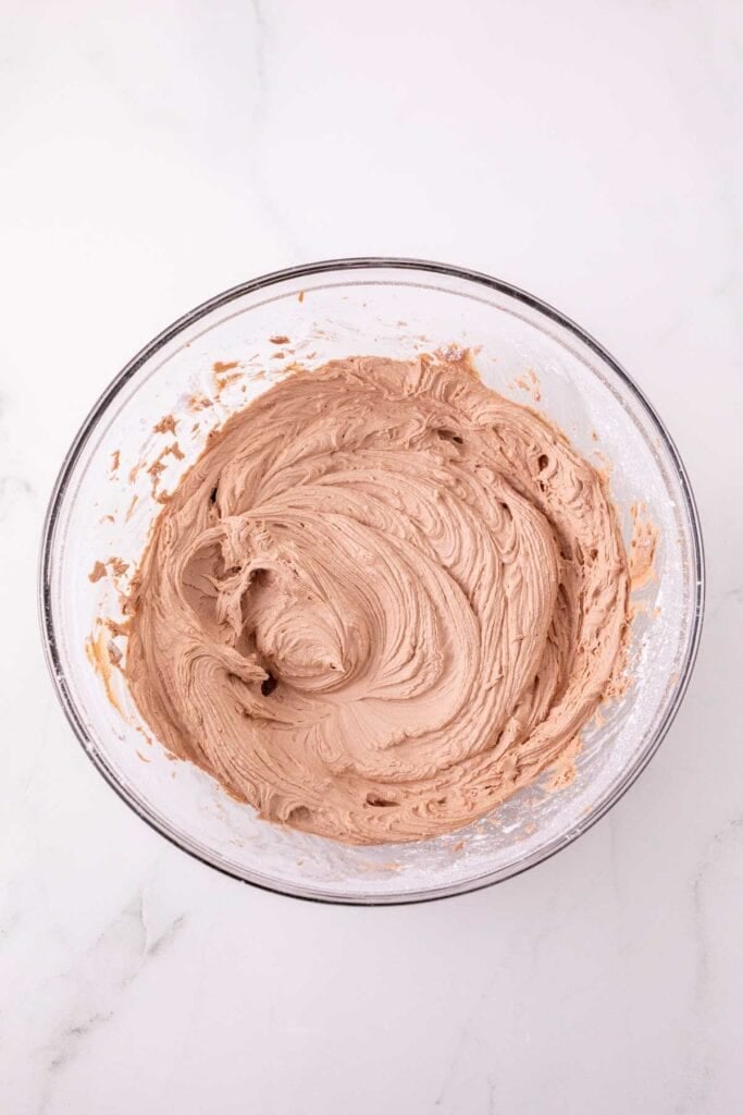 powdered sugar blended into nutella and butter mixture in a mixing bowl