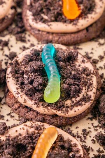 These Dirt and Worms Cookies are the ultimate fun and easy Halloween dessert for kids and adults! Rich chocolate cookies are topped with creamy Nutella frosting, crushed Oreo cookie “dirt,” and colorful gummy worms for a spooky treat that’s almost too cute to eat. If you’re searching for Halloween Cookies, Halloween Dessert Recipes, Spooky Cookies, Dirt and Worm Cookies, Gummy Worm Desserts, Oreo Desserts, or Easy Halloween Treats, save this recipe! These creepy-cute cookies are perfect for Halloween Party Food, Halloween Baking Ideas Easy, Halloween Food For Party, Halloween Treats For Kids, Spooky Halloween Desserts, Halloween Cookie Ideas, and fun classroom treats. With store bought cookie dough and simple decorating, these easy Halloween cookies come together quickly for parties, movie nights, and October celebrations.