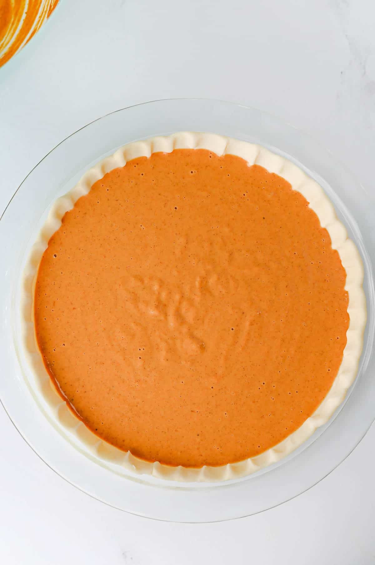 pumpkin pie filling in crust before baking