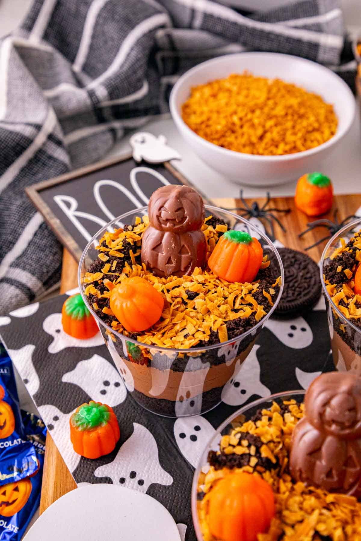 These Halloween Dirt Cups are an easy no bake Halloween dessert perfect for parties, kids, and spooky season celebrations! Creamy chocolate peanut butter pudding is layered with crushed Oreo cookies to create delicious Oreo dirt cups, then topped with toasted coconut, mellowcreme pumpkins, and jack o lantern chocolates. If you need easy Halloween desserts, Halloween party food, Halloween treats for kids, or fun Halloween dessert ideas, these pudding dirt cups are a must-try. These Halloween pudding cups take just 15 minutes to prepare and are served in individual cups for an easy party dessert. Make these spooky dirt cups for a Halloween party, school celebration, fall gathering, or movie night. They're a fun twist on classic Oreo dirt pudding and an easy Halloween treat everyone will want to dig into!
