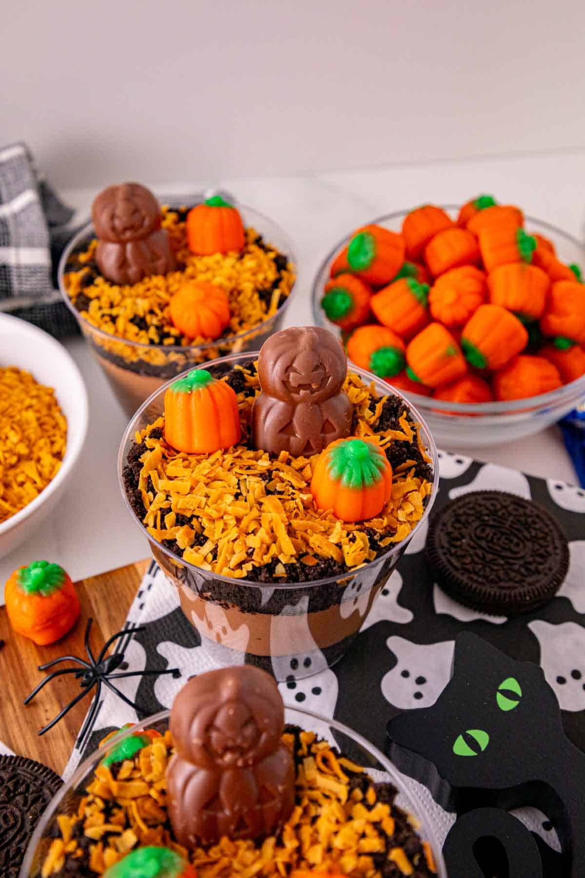 These Halloween Dirt Cups are an easy no bake Halloween dessert perfect for parties, kids, and spooky season celebrations! Creamy chocolate peanut butter pudding is layered with crushed Oreo cookies to create delicious Oreo dirt cups, then topped with toasted coconut, mellowcreme pumpkins, and jack o lantern chocolates. If you need easy Halloween desserts, Halloween party food, Halloween treats for kids, or fun Halloween dessert ideas, these pudding dirt cups are a must-try. These Halloween pudding cups take just 15 minutes to prepare and are served in individual cups for an easy party dessert. Make these spooky dirt cups for a Halloween party, school celebration, fall gathering, or movie night. They're a fun twist on classic Oreo dirt pudding and an easy Halloween treat everyone will want to dig into!