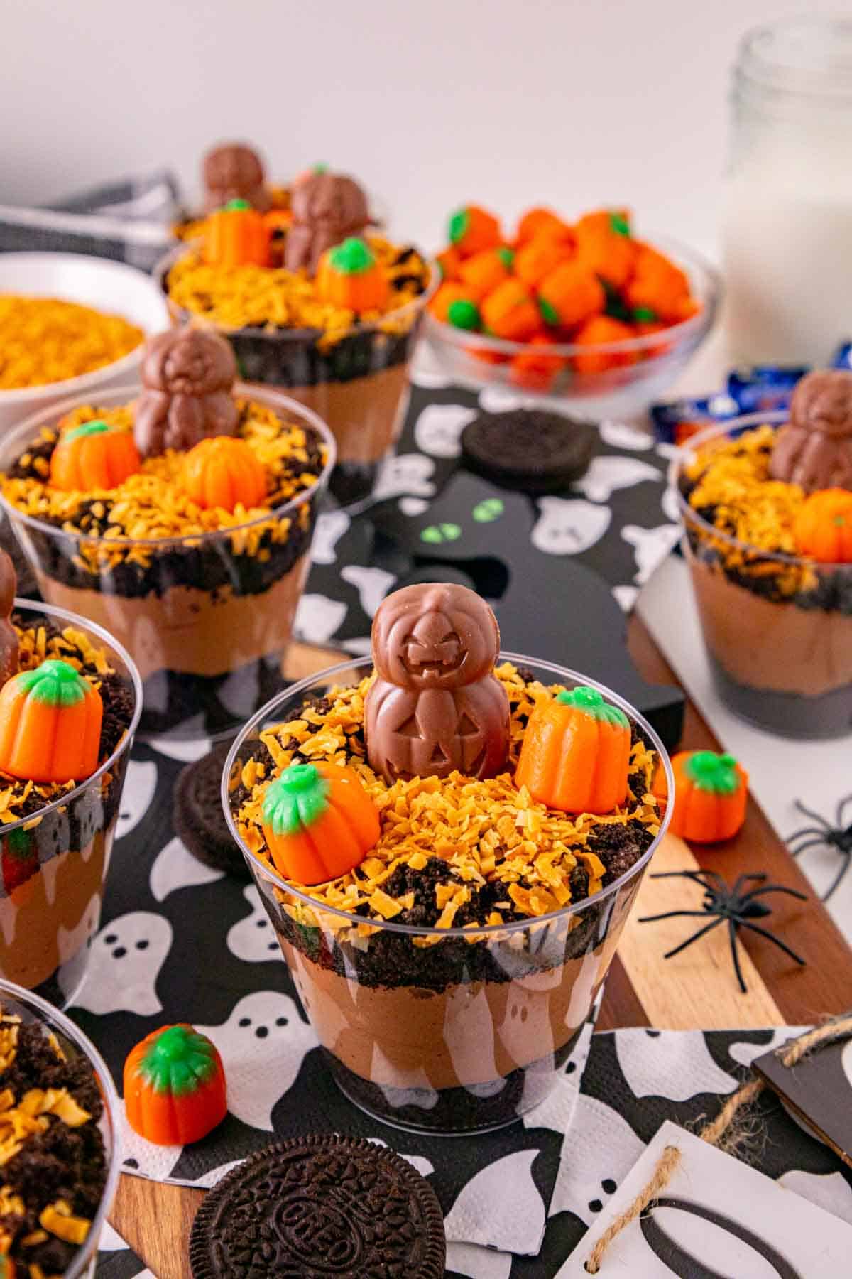 These Halloween Dirt Cups are an easy no bake Halloween dessert perfect for parties, kids, and spooky season celebrations! Creamy chocolate peanut butter pudding is layered with crushed Oreo cookies to create delicious Oreo dirt cups, then topped with toasted coconut, mellowcreme pumpkins, and jack o lantern chocolates. If you need easy Halloween desserts, Halloween party food, Halloween treats for kids, or fun Halloween dessert ideas, these pudding dirt cups are a must-try. These Halloween pudding cups take just 15 minutes to prepare and are served in individual cups for an easy party dessert. Make these spooky dirt cups for a Halloween party, school celebration, fall gathering, or movie night. They're a fun twist on classic Oreo dirt pudding and an easy Halloween treat everyone will want to dig into!