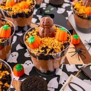 These Halloween Dirt Cups are an easy no bake Halloween dessert perfect for parties, kids, and spooky season celebrations! Creamy chocolate peanut butter pudding is layered with crushed Oreo cookies to create delicious Oreo dirt cups, then topped with toasted coconut, mellowcreme pumpkins, and jack o lantern chocolates. If you need easy Halloween desserts, Halloween party food, Halloween treats for kids, or fun Halloween dessert ideas, these pudding dirt cups are a must-try. These Halloween pudding cups take just 15 minutes to prepare and are served in individual cups for an easy party dessert. Make these spooky dirt cups for a Halloween party, school celebration, fall gathering, or movie night. They're a fun twist on classic Oreo dirt pudding and an easy Halloween treat everyone will want to dig into!